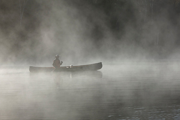 Paddling a Canoe on a Misty Lake