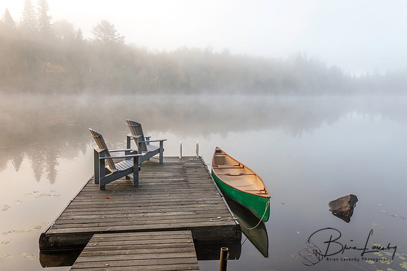 Green Canoe and Dock on a Misty Morning