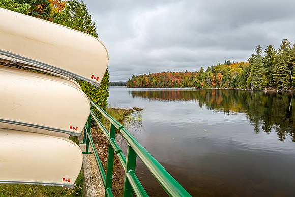 Canoes Stored on a Rack Overlooking a Lake in Autumn